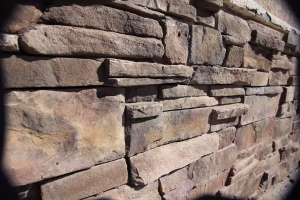 Dry stack natural stone retaining wall surrounding an outdoor fire pit | Johns Creek Georgia